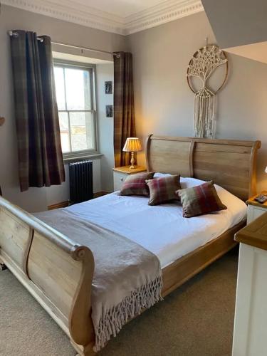a bedroom with a large wooden bed with two pillows at Newgate House in Morpeth