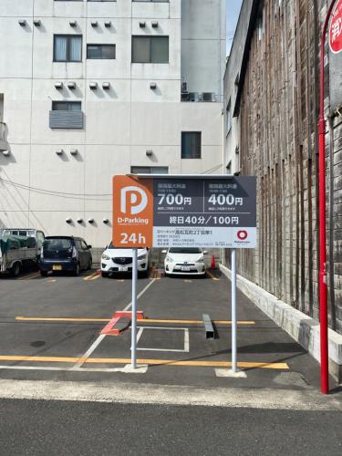 a parking lot with a parking sign in front of a building at 瓦町駅•home 101 in Takamatsu