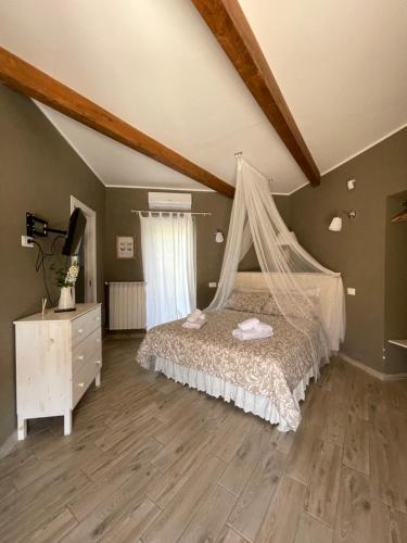 Schlafzimmer mit einem Bett mit Moskitonetz in der Unterkunft Tenuta calidarius in Baia