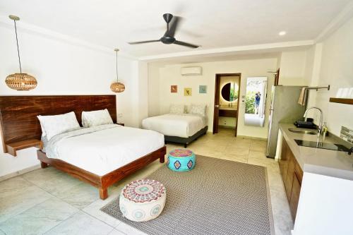 a bedroom with a bed and a kitchen with a sink at Hotel Puerto Sayulita in Sayulita