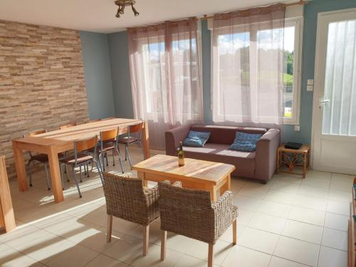 a living room with a couch and a table at Les 3 mômes in Pontorson