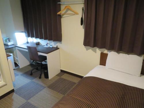 Habitación de hotel con cama y escritorio con ordenador en Hotel Marue - Vacation STAY 78769v, en Kamaishi