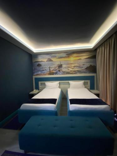 a room with three beds and a painting on the wall at New W Hotel in Tirana