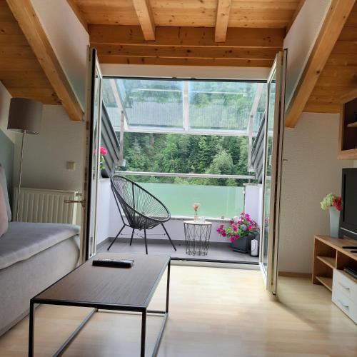 a living room with a chair and a table at Appartement Au in Oberperfuss