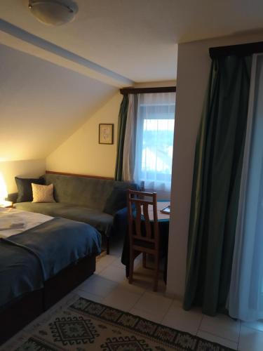 una camera con letto, scrivania e finestra di Nimród Pihenőház a Egerszalók