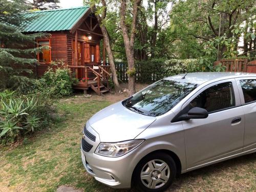 a silver car parked in front of a log cabin at Cabaña Las Nubes in Río Ceballos