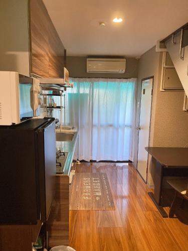a room with a kitchen with a refrigerator and a table at 瓦町駅•home 101 in Takamatsu
