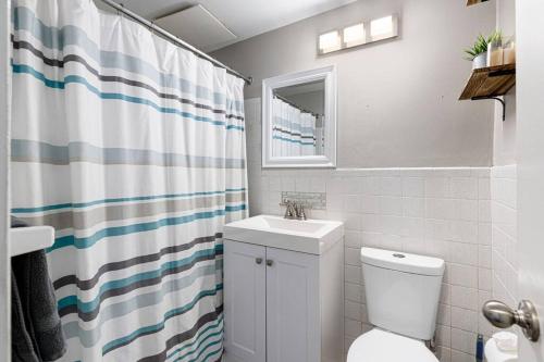 a bathroom with a toilet and a sink and a shower curtain at 1001 Free Parking, 2 Bd, Modern DTW, Great Wifi in Atlanta