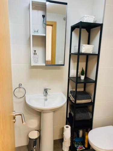 a bathroom with a sink and a mirror at Apartamentos LAMAROSA -PLAYA URBANA in Burela de Cabo