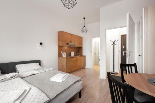 a bedroom with a bed and a dining table at Apartamenty przy Ścieżce Kościelnej in Elblag