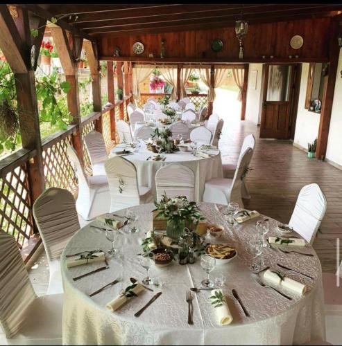 a group of tables with white chairs and plates of food at Pensiunea Elena in Criţ