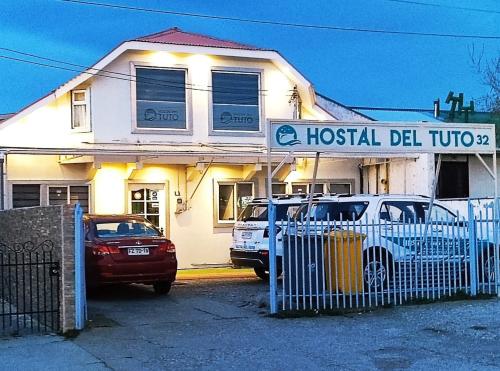 2 auto parcheggiate di fronte a un ostello del tutor di Hostal Del Tuto a Punta Arenas