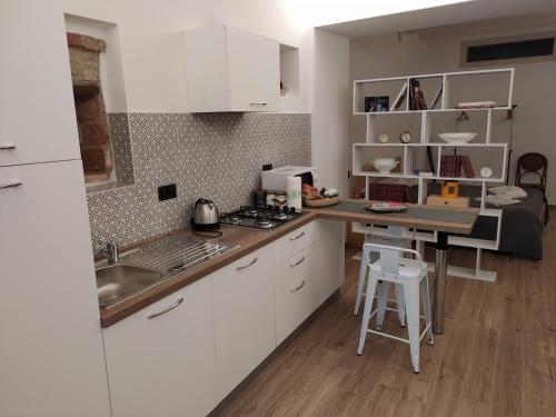 a kitchen with white cabinets and a counter top at Casa Mantel Holiday Home Panoramic view in Langhe in Novello