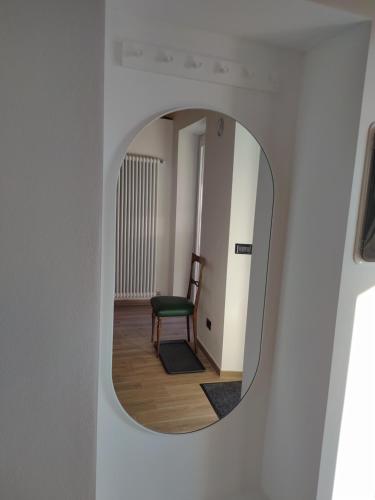 a mirror on a wall with a chair in a room at Casa Mantel Holiday Home Panoramic view in Langhe in Novello