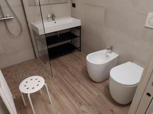 a white bathroom with a toilet and a sink at Casa Mantel Holiday Home Panoramic view in Langhe in Novello