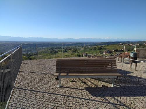 a wooden bench sitting on top of a hill at Casa Mantel Holiday Home Panoramic view in Langhe in Novello
