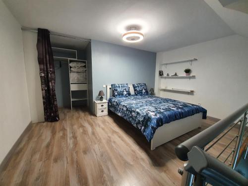 - une chambre avec un lit et une couette bleue dans l'établissement Nuits & Jours Duplex à Nuits Saint Georges, à Nuits-Saint-Georges