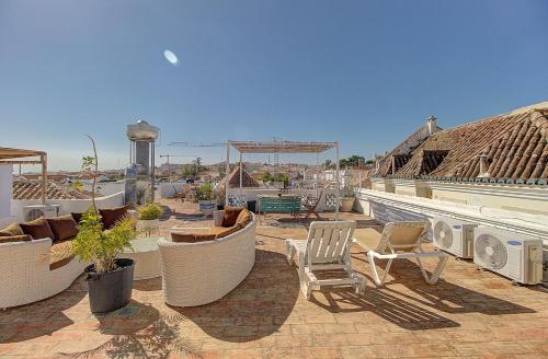 a patio with chairs and tables on a roof at Lagoas in Tavira