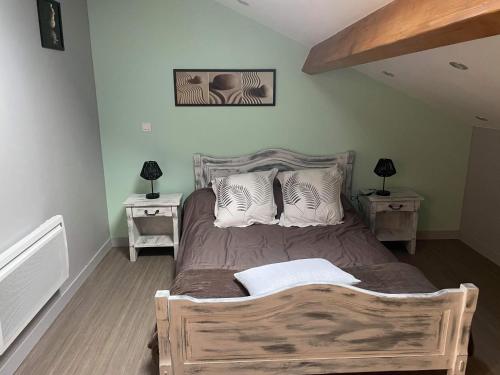 1 dormitorio con 1 cama de madera y 2 mesitas de noche en les rouardes, en Sainte-Croix-en-Jarez