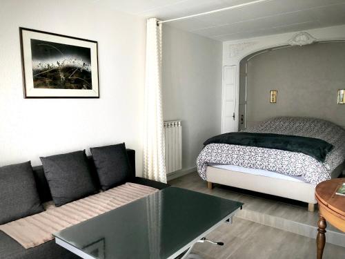 sala de estar con cama y sofá en Le Gîte du Sommerberg en Niedermorschwihr