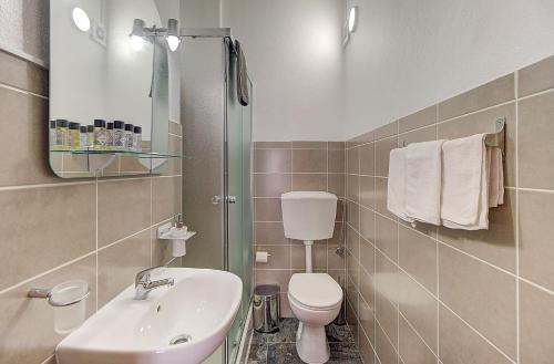 a bathroom with a sink and a toilet and a mirror at Lagoas in Tavira