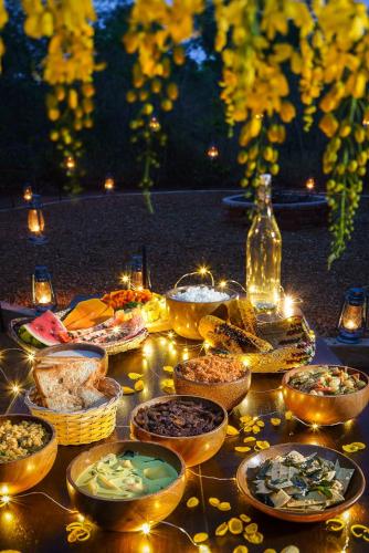 a table with many bowls of food and lights at Makini Bush Camp, Yala in Yala