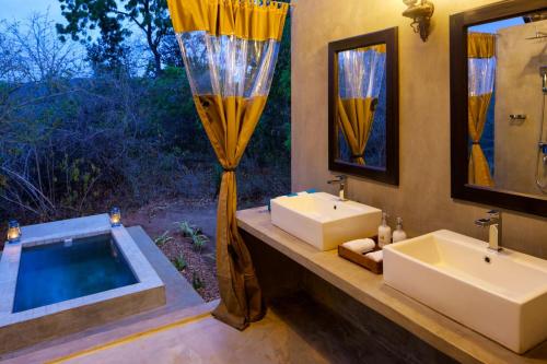 uma casa de banho com 2 lavatórios e uma banheira em Makini Bush Camp, Yala em Yala
