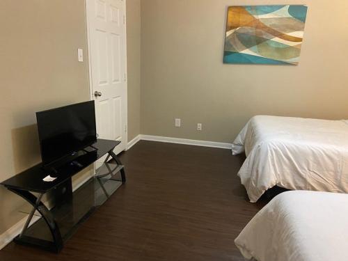a room with two beds and a television on a table at Resort Style Apt/Home in Houston Medical Centre in Houston