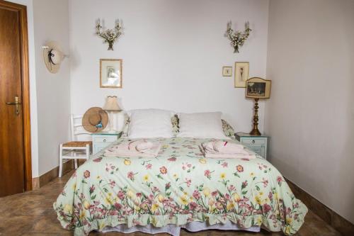 een slaapkamer met een bed met een bloemenbed bij B&B Etruscan Garden in Sutri