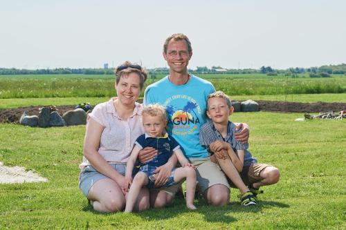 a family sitting on the grass in a field at Gadegaard Apartment in Ringkøbing