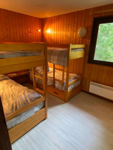 a room with two bunk beds and a window at Loge des rêveurs in Les Carroz d'Araches