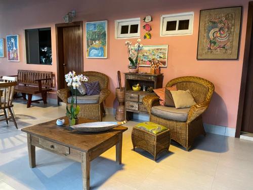 een woonkamer met rieten stoelen en een tafel bij Casa do Lago Hospedaria in Brasilia