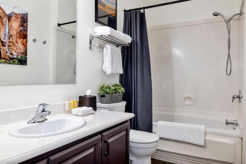 
a bathroom with a shower, sink, and toilet at Red Rock Inn Cottages in Springdale
