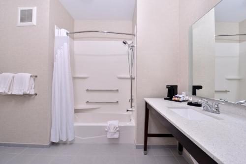 ein weißes Bad mit einer Dusche und einem Waschbecken in der Unterkunft Holiday Inn Express Hotels & Suites Loma Linda, an IHG Hotel in Loma Linda