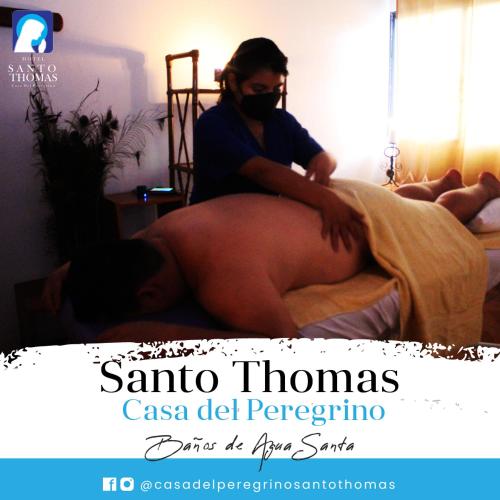 a woman is sitting on a bed with her buttressedearch at Casa del Peregrino Santo Thomas in Baños