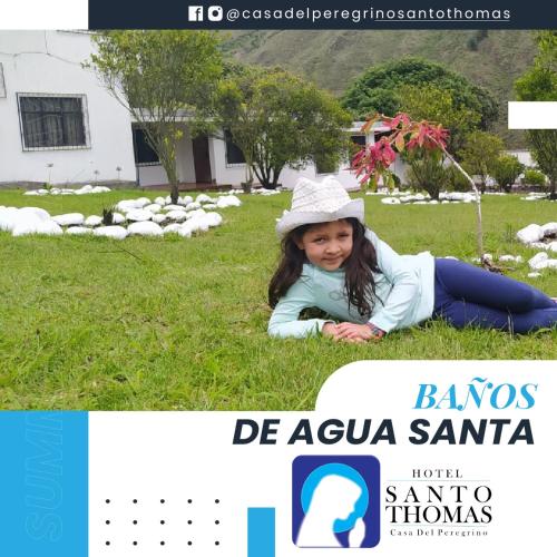 a little girl laying in the grass at Casa del Peregrino Santo Thomas in Baños