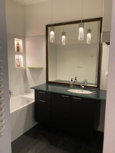y baño con lavabo, espejo y bañera. en Let’s Dream Apartment 68 m2 en Cracovia