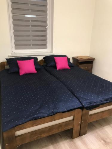 a bed with two pink pillows in a bedroom at Agroturystyka "Zielone Zacisze" in Łagów