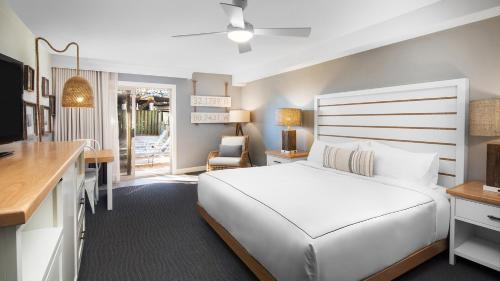 a bedroom with a large white bed and a desk at Beach House Resort Hilton Head Island in Hilton Head Island