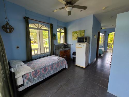 a bedroom with a bed and a kitchen with a refrigerator at Hermosa Beach House in Playa Hermosa