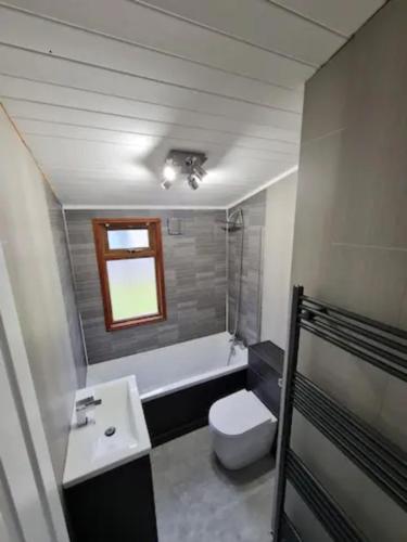 a bathroom with a toilet and a sink and a tub at 4 Bed Luxury Lodge with Hot tub near Lake District in Warton