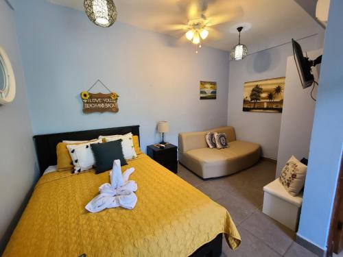 a bedroom with a yellow bed and a couch at Hermosa Beach House in Playa Hermosa