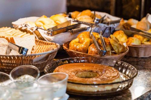 a table topped with baskets of bread and pastries at Búzios Centro Hotel in Búzios