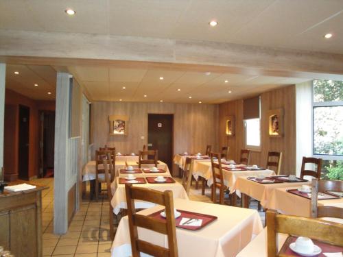 a dining room filled with tables and chairs at Hotel Le Drakkar in Pont-Audemer
