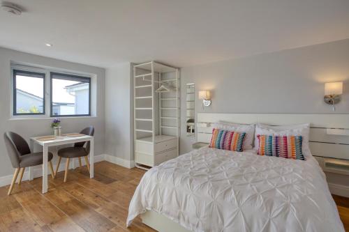 a bedroom with a bed and a desk and a window at Pebbles King Studio in St Ives