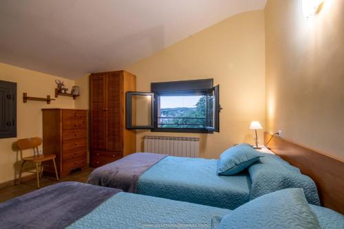 1 dormitorio con 2 camas y ventana en Casa rural Graeras en Castigaleu, en Castigaleu