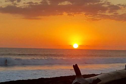 a person laying on the beach at sunset at Hermosa Beach House in Playa Hermosa