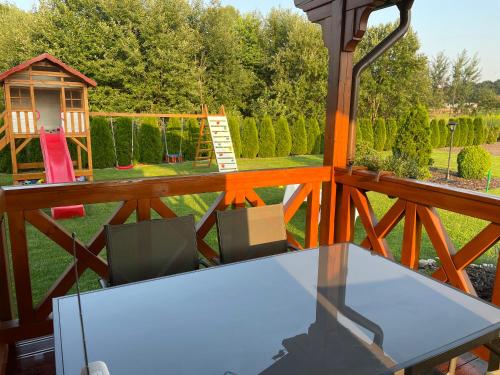 a table and chairs on a balcony with a playground at Sielanka Chwaliszów dom całoroczny in Chwaliszow