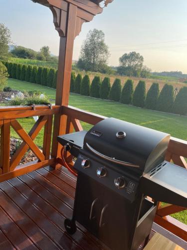 a grill on a deck with a view of a field at Sielanka Chwaliszów dom całoroczny in Chwaliszow