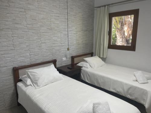 a bedroom with two beds and a window at Apartamentos Finca Wapa in Frontera